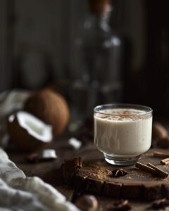 "Person preparing coquito tea recipe in kitchen, ingredients displayed on countertop."